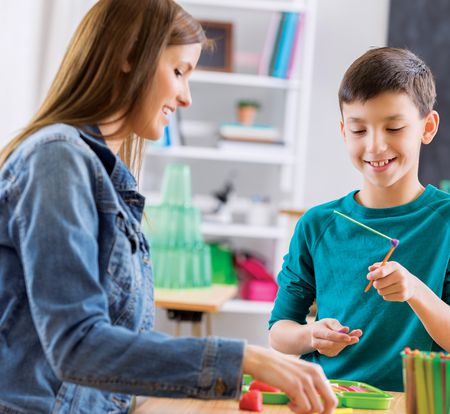 Woman teacher interacting with boy student.